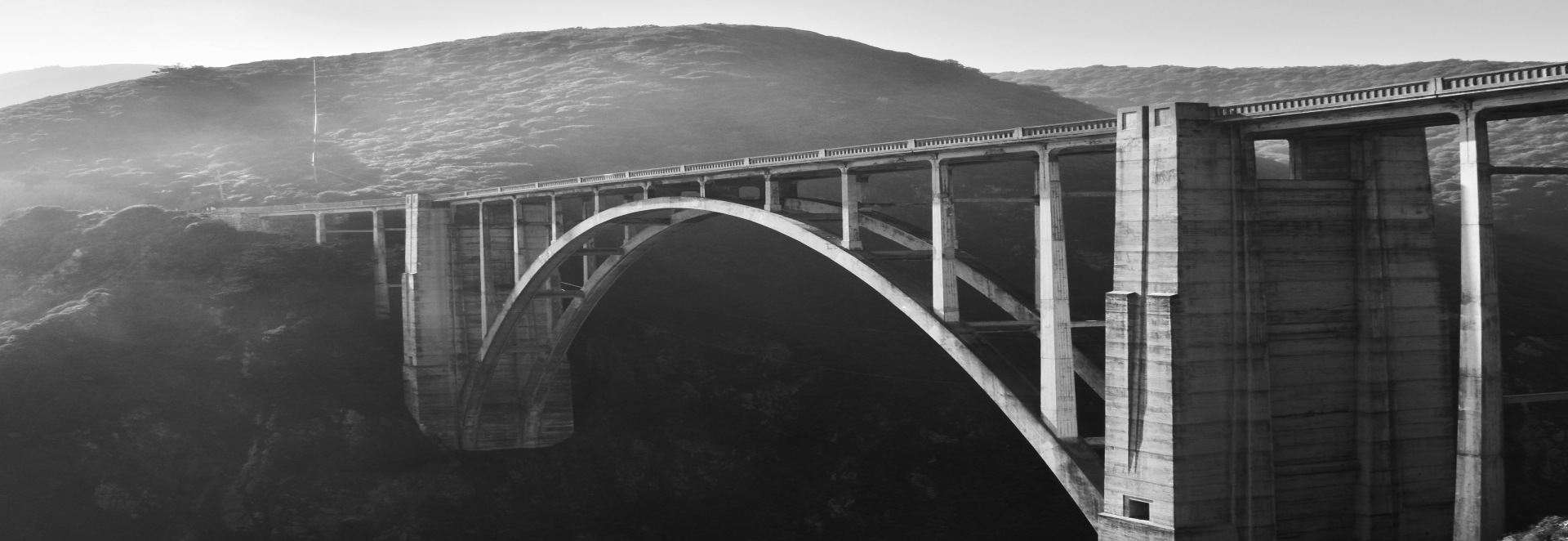 Black-and-white photograph of an arched concrete bridge